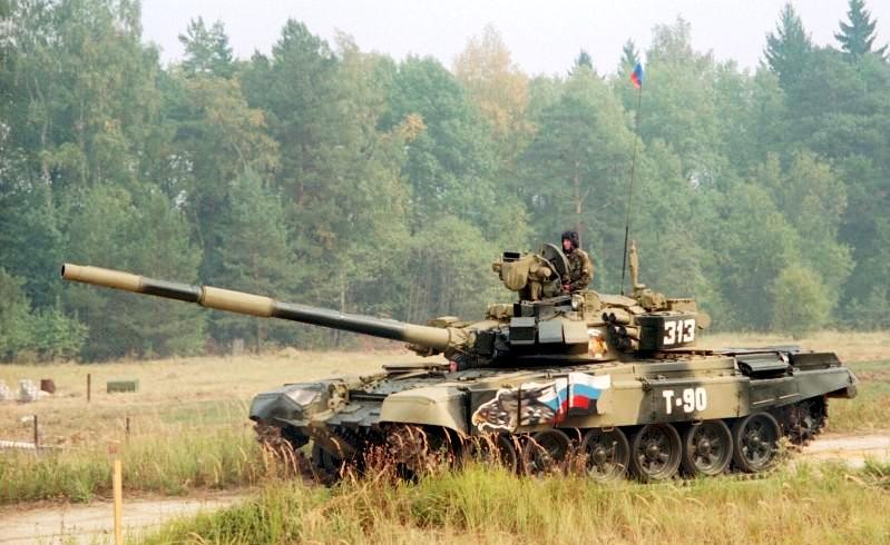<strong>Czołg T-90</strong>
<br></br>
Rosyjski czołg T-90 jest produkowany seryjnie od ponad 20 lat i należy do najnowocześniejszych jednostek tego typu na świecie. Wyposażono go m.in. w pancerz reaktywny nowej generacji. Składa się on z kostek wypełnionych ładunkiem wybuchowym. W przypadku, kiedy pocisk trafia T-90, kostki pancerza reaktywnego eksplodują. Taka kontreksplozja redukuje przebijalność nacierające pocisku i rozprasza jego siłę. 
<br></br>
Silnym punktem czołgów T-90 jest także system ochrony Sztora. Umieszczone po bokach lufy reflektory promieniowania podczerwonego zakłócają systemy naprowadzania rakietowych pocisków przeciwpancernych. Czołg T-90 potrafi bronić się także przeciw pociskom samonaprowadzającym się laserowo. System Sztora wykrywa moment, w którym czołg został naświetlony laserem nadlatującego pocisku i w ciągu 3 sekund wystrzeliwuje w kierunku pocisku granaty, które tworzą zasłonę antylaserową w odległości 55-70 metrów od czołgu.  
<br></br>
fot. Autor: User:Jno, CC BY-SA 1.0, Wikimedia Commons