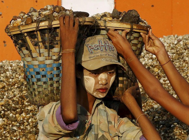 Labourers unload gravel from a boat docked in Dala township, opposite Yangon city, Myanmar