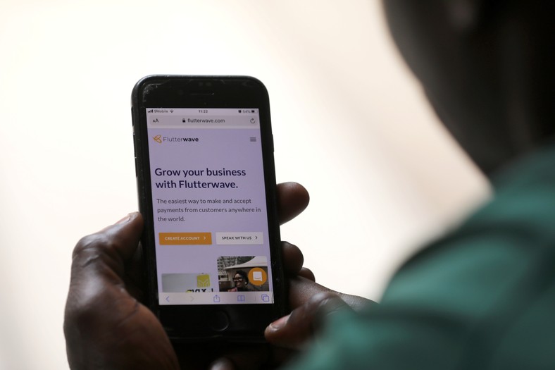 A man poses as he displays the Flutterwave homepage on a mobile phone screen in Abuja, Nigeria January 21, 2020. REUTERS/Afolabi Sotunde