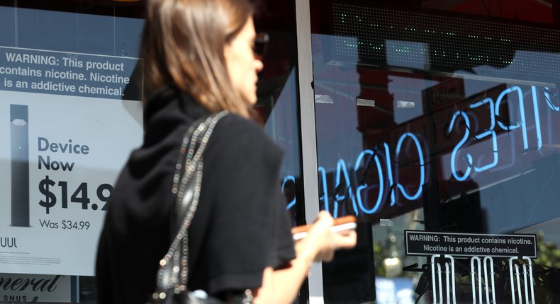 A pedestrian walks by a window advertisement for Juul products in 2019 in San Francisco, California.