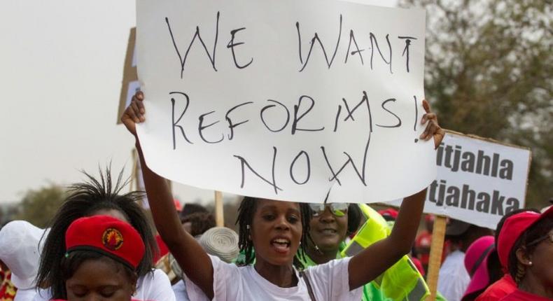 A protester holds a placard as Zimbabwe opposition supporters under the National Electoral Reform (NERA) coalition march through the streets of Bulawayo, on September 17, 2016