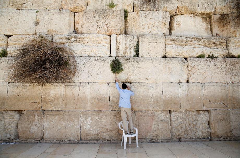 Men clear notes placed in the cracks of the Western Wall, Judaism's holiest prayer site, to clear sp