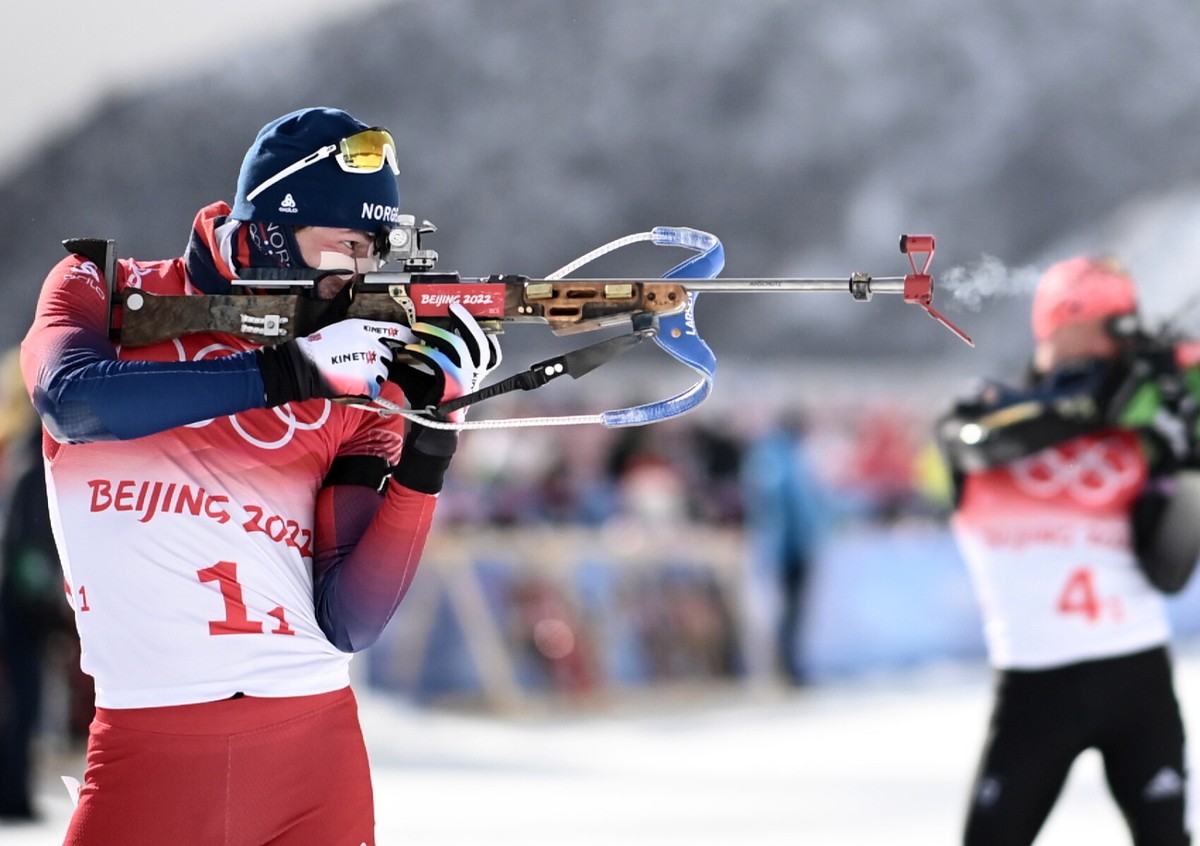 Norweg Sturla Holm Laegreid (L) na strzelnicy podczas rywalizacji biathlonowych sztafet mężczyzn 4x7,5 km podczas igrzysk olimpijskich w Pekinie