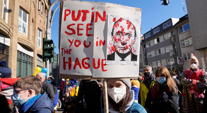 A girl holds a sign reading Putin see you in The Hague in Cologne, Germany, during a peace march against the war in Ukraine on Shrove Monday, Feb. 28, 2022.