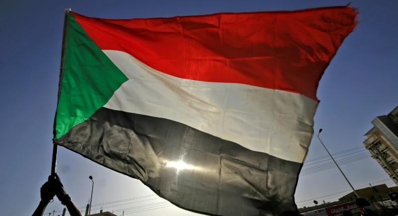 The Sudanese flag flies in Khartoum during a commemoration of a deadly raid a year ago on an anti-government sit-in