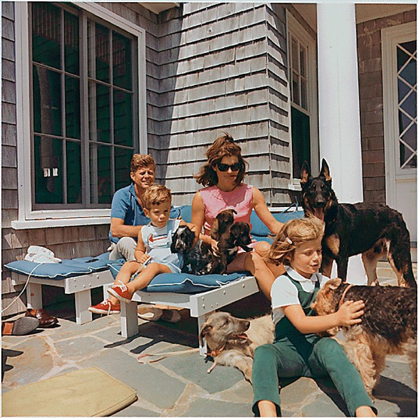 Rodzina Kennedych. Prezydent Kennedy, John F. Kennedy Jr., pierwsza dama Jacqueline Kennedy, Caroline Kennedy. Psy: Clipper (stoi), Charlie (z Caroline), Wolf (leży), Shannon (z Johnem Jr.), dwa szczeniaki Pushinki (z panią Kennedy)