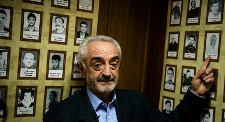 Marinko Djuric points at a photograph of his missing father who was among seven members of his family who disappeared in northwestern Kosovo during the conflict in the 1990s