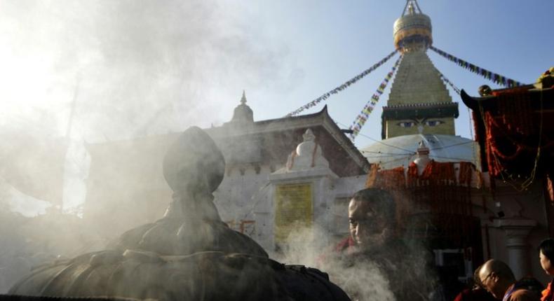 A Buddhist devotee lights incense at Kathmandu's Boudhanath stupa on November 22, 2016