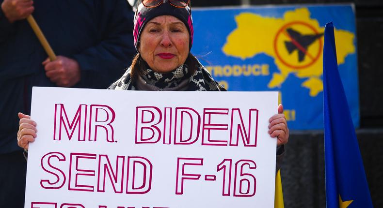 A woman holds a banner 'Mr Biden Send F-16 To Ukraine' during a daily demonstration of solidarity with Ukraine at the Main Square one day ahead of one-year anniversary of Russian invasion on Ukraine. Krakow, Poland on February 23, 2023.Beata Zawrzel/NurPhoto via Getty Images