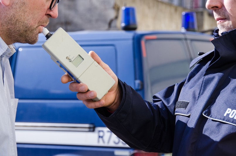 Policjant badający kierowcę alkomatem