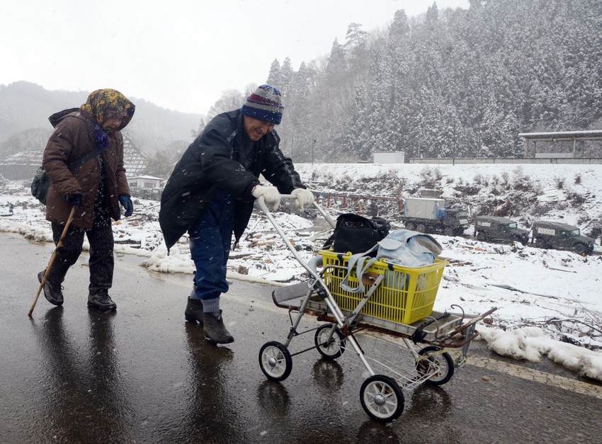 Stanovnici Mijaka sa spasenim stvarima iz ruševina
