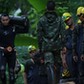 A diver carries an oxygen tank as he leaves the Tham Luang cave complex, where 12 boys and their soc