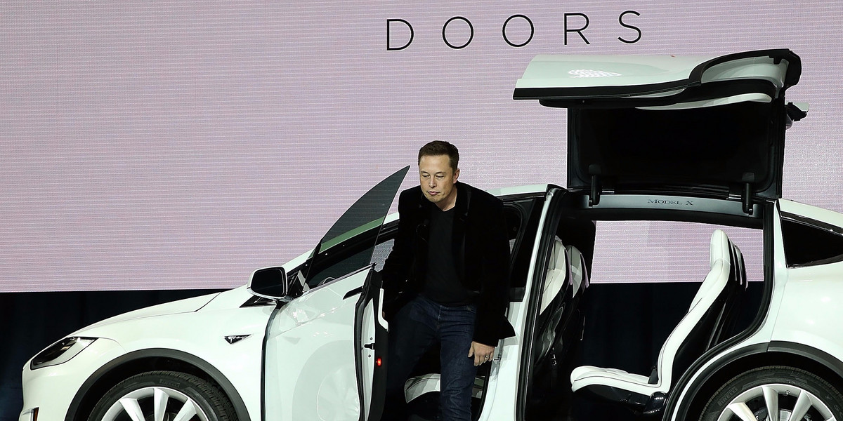 Tesla CEO Elon Musk demonstrates the falcon wing doors on the new Tesla Model X Crossover SUV during a launch event on September 29, 2015 in Fremont, California. After several production delays, Elon Musk officially launched the much anticipated Tesla Model X Crossover SUV.