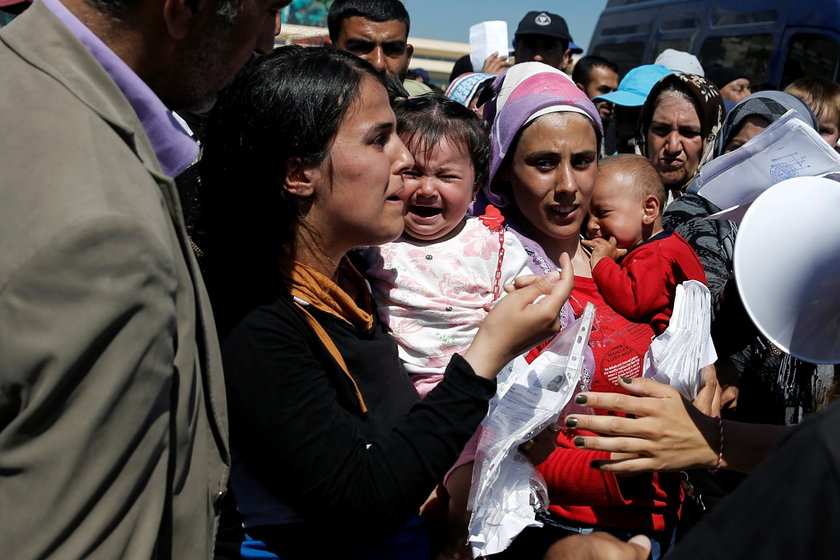 Kobieta z dzieckiem próbuje uzyskać informację o transporcie do obozu dla uchodźców w Grecji