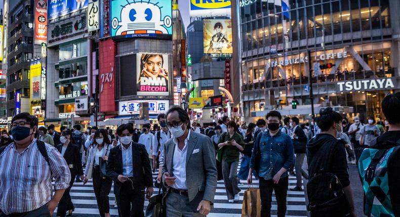People wearing face masks cross Shibuya crossing on May 28 in Tokyo, Japan.
