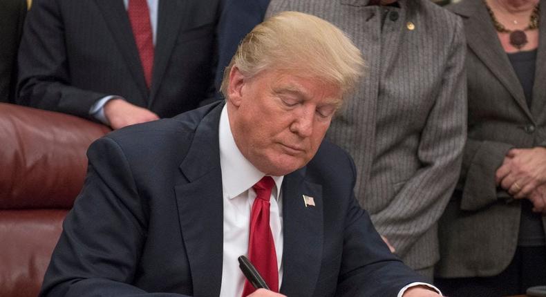 President Donald Trump signs a bipartisan bill to stop the flow of opioids into the United States in the Oval Office of the White House on January 10, 2018 in Washington, DC.