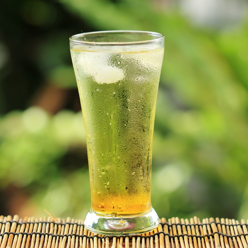 gold guarana soft drink with ice cubes