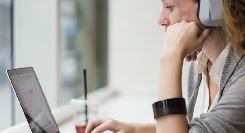 woman using mac laptop headphones