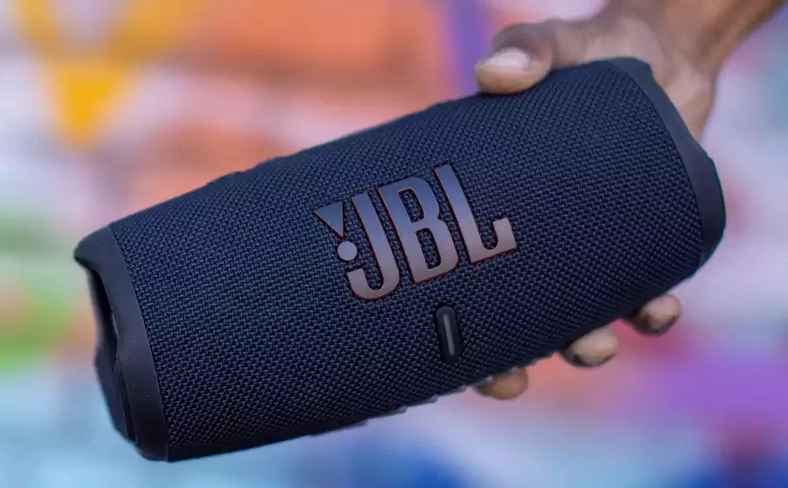 Charge 5 to najnowsza odsłona przenośnego głośnika Bluetooth firmy JBL. Wodoszczelna obudowa, akumulator 7200 mAh (do 20 godzin pracy) z funkcją powerbanku i masa około 1 kilograma sprawiają, że sprawdzi się on zarówno w domu, jak i w terenie