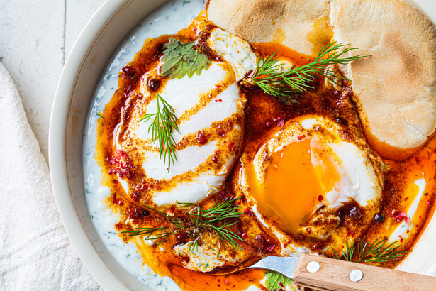 Jajka po turecku można podawać z podpieczonym na chrupko chlebem.