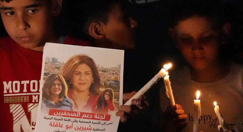 Palestinian children with candles and pictures of slain Al Jazeera journalist Shireen Abu Akleh in Gaza City, May 11, 2022.