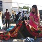 A woman stands near an injured person outside of a hospital after an earthquake hit Sembalun Selong village in Lombok Timur