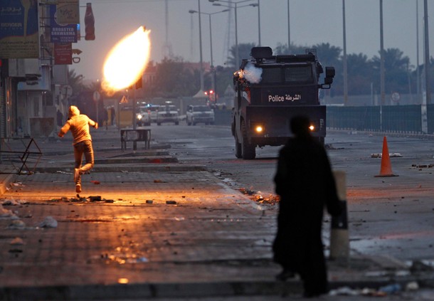 A protester throws molotove at riot police armoured personnel carrier and at the same time tear gas 