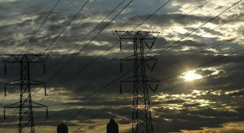 Electricity pylons in Johannesburg's Alexandra township stand against the skyline of the city's Sandton business district in this file photo. REUTERS/Mike Hutchings/Files