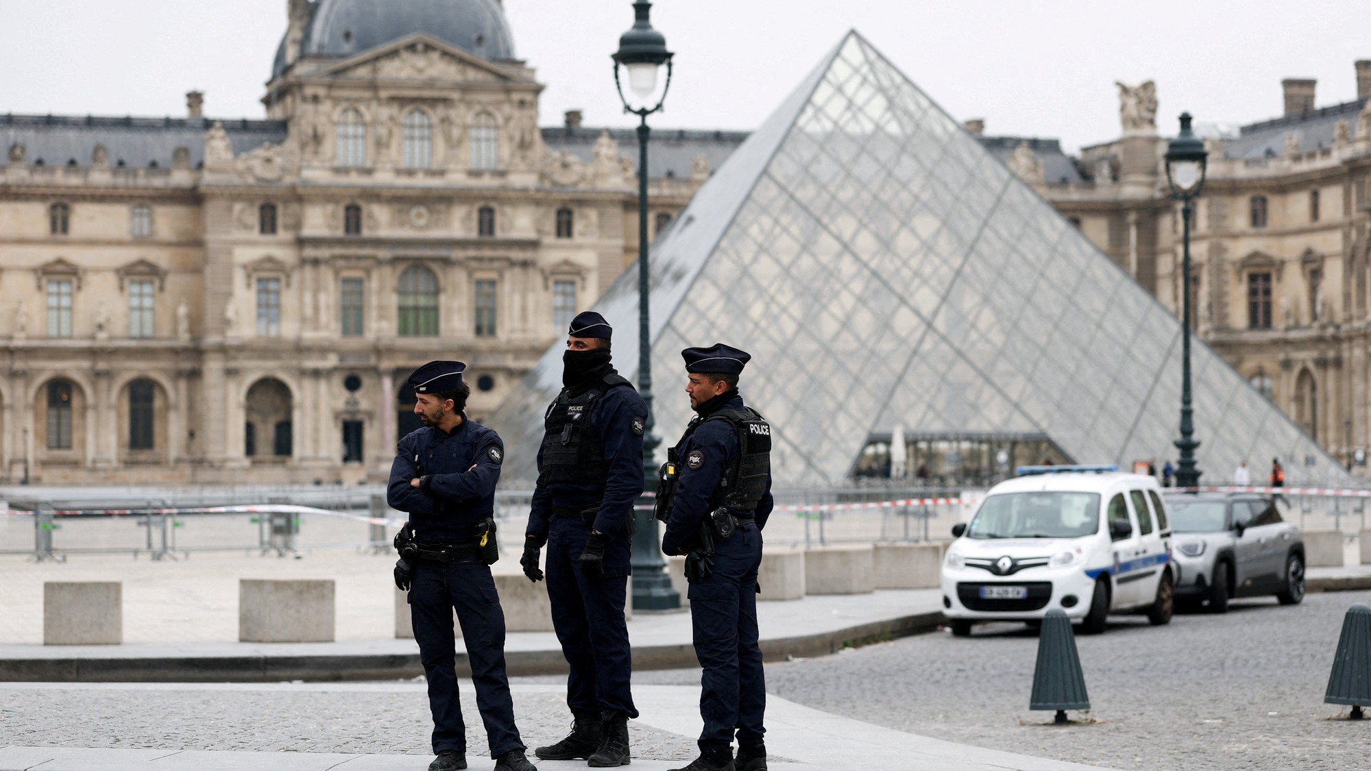 Policajti stoja pri pyramíde múzea Louvre po správach o lúpeži v Paríži vo Francúzsku, REUTERS/Gonzalo Fuentes