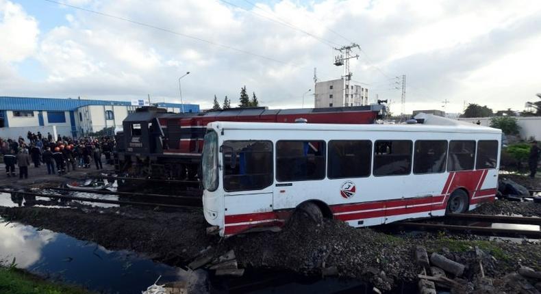 Tunisian security officers inspect the wreckage after a train smashed into a bus near Sidi Fathallah, on December 28, 2016