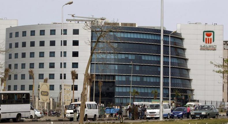 People and vehicles are seen in front of the National Bank of Egypt (NBE), also known as the Al Ahli Bank, in the Fifth Settlement districts of New Cairo March 30, 2013. REUTERS/Amr Abdallah Dalsh