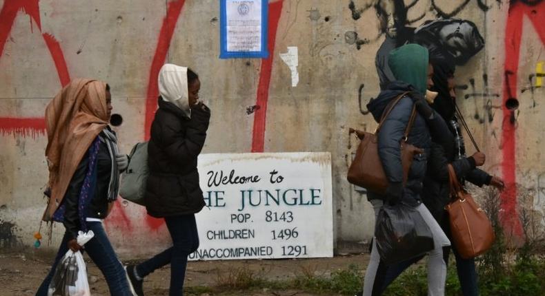 Migrants carry their belongings as they leave the Jungle camp in Calais, northern France, on October 24, 2016