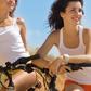 Two attractive girls on a beach with bicycles