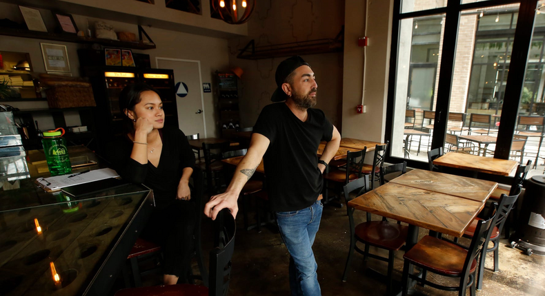 Employees stand in the empty dining room of a Sacramento, California restaurant on March 17, 2020.