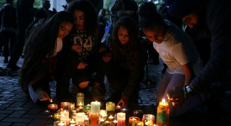 People light candles after a silent march in memory of the victims of the Grenfell Tower fire