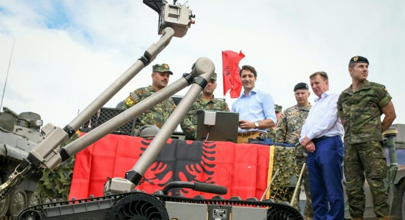 Canadian Prime Minister Justin Trudeau observes a military robot as he meets with Latvian, Canadian and other NATO soldiers in Adazi, Latvia, in July 2018