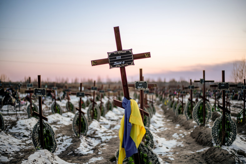 Groby nieznanych cywilów zabitych w pierwszych tygodniach rosyjskiej inwazji na Ukrainę na cmentarzu w Buczy, Ukrainie, 23 lutego 2023 r.