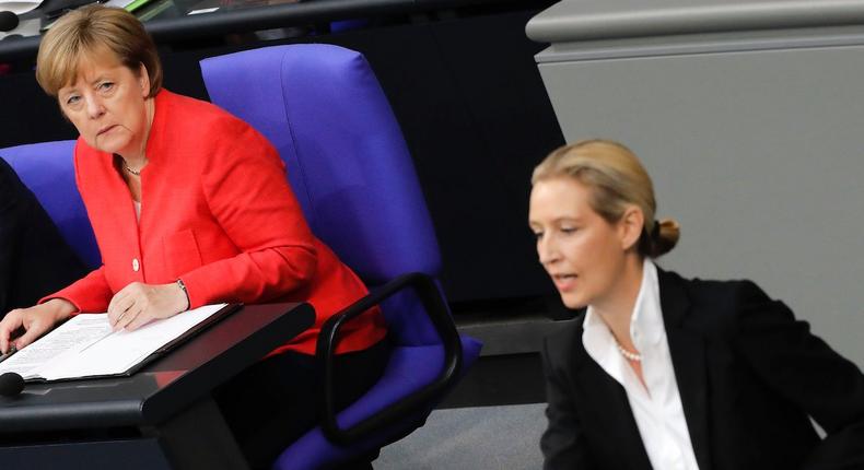 German Chancellor Angela Merkel, left, listens to Alice Weidel, co-faction leader of the Alternative for Germany party, during a budget debate at the German parliament Bundestag at the Reichtsag building in Berlin, Wednesday, July 4, 2018.