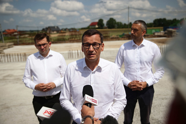 Premier Mateusz Morawiecki, wicemarszałek Senatu Marek Pęk (P) i wojewoda małopolski Łukasz Kmita (L) podczas wizyty na budowie obwodnicy Krakowa