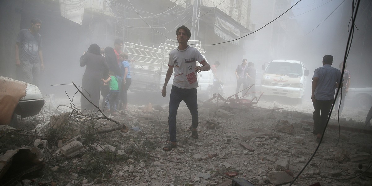 Residents flee a site after an air strike on the rebel-held besieged town of Douma, eastern Damascus suburb of Ghouta, Syria August 20, 2016.