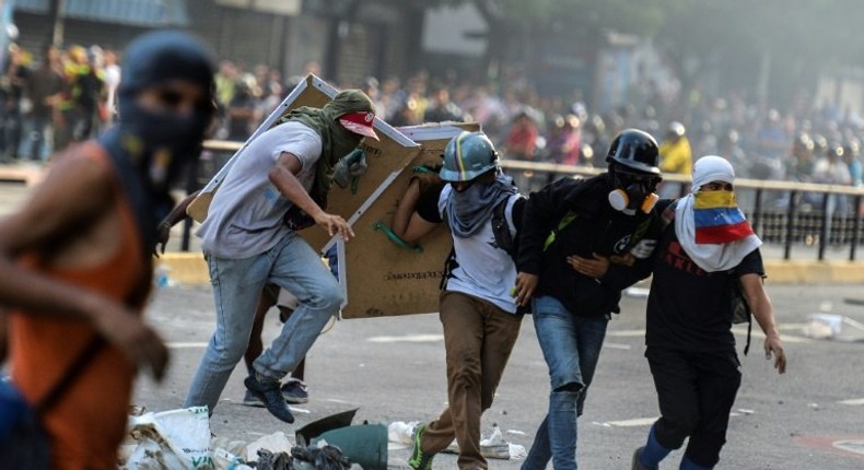 An injured Venezuelan anti-government demonstrator (2nd from right) is assisted by fellow activists during an attack at the Supreme Court -- the latest protest against President Nicolas Maduro in Caracas