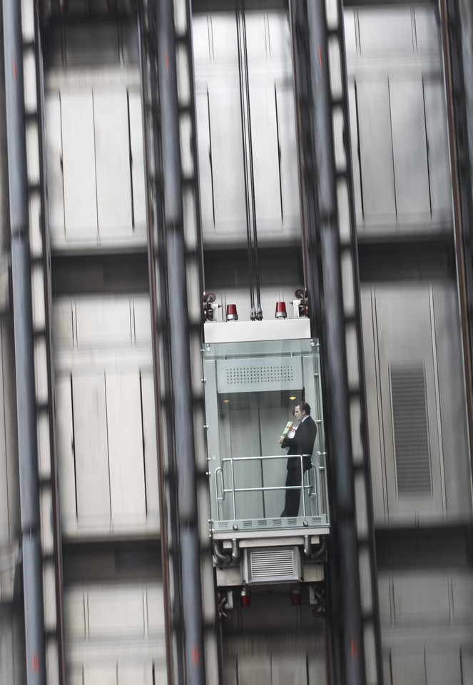 A man descends in an elevator at the Lloyds Insurance building in the City of London
