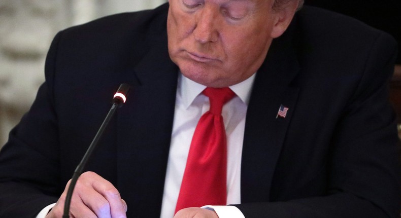 Former President Donald Trump uses a smartphone.