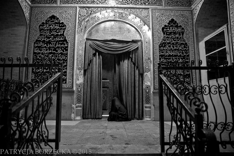  Muzułmanka modli się pod bocznym wejściem do meczetu w trakcie ceremonii związanych z Muharram. Isfahan, Iran, 2015