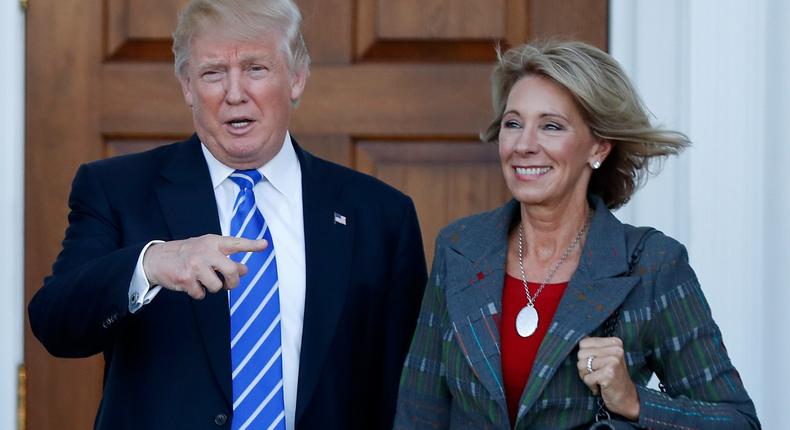 Donald Trump and Betsy DeVos pose for photographs at Trump National Golf Club in Bedminster, N.J.