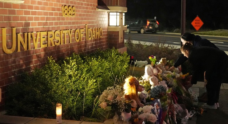 Two people place flowers at a growing memorial in front of a campus entrance sign for the University of Idaho, Wednesday, Nov. 16, 2022, in Moscow, Idaho.AP Photo/Ted S. Warren