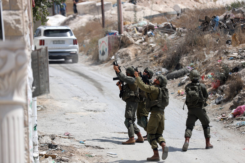 Izraelski personel bezpieczeństwa rozmieszczony na miejscu strzelaniny na południe od miasta Hebron na Zachodnim Brzegu w dniu 21 sierpnia 2023 r.