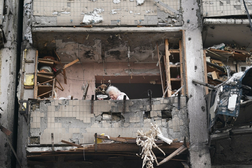 Kobieta w gruzach budynku mieszkalnego w Kijowie, w który uderzyła rakieta 