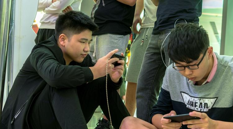 Kínai fiatalok telefonon játszanak - szigorúan három óránál kevesebbet