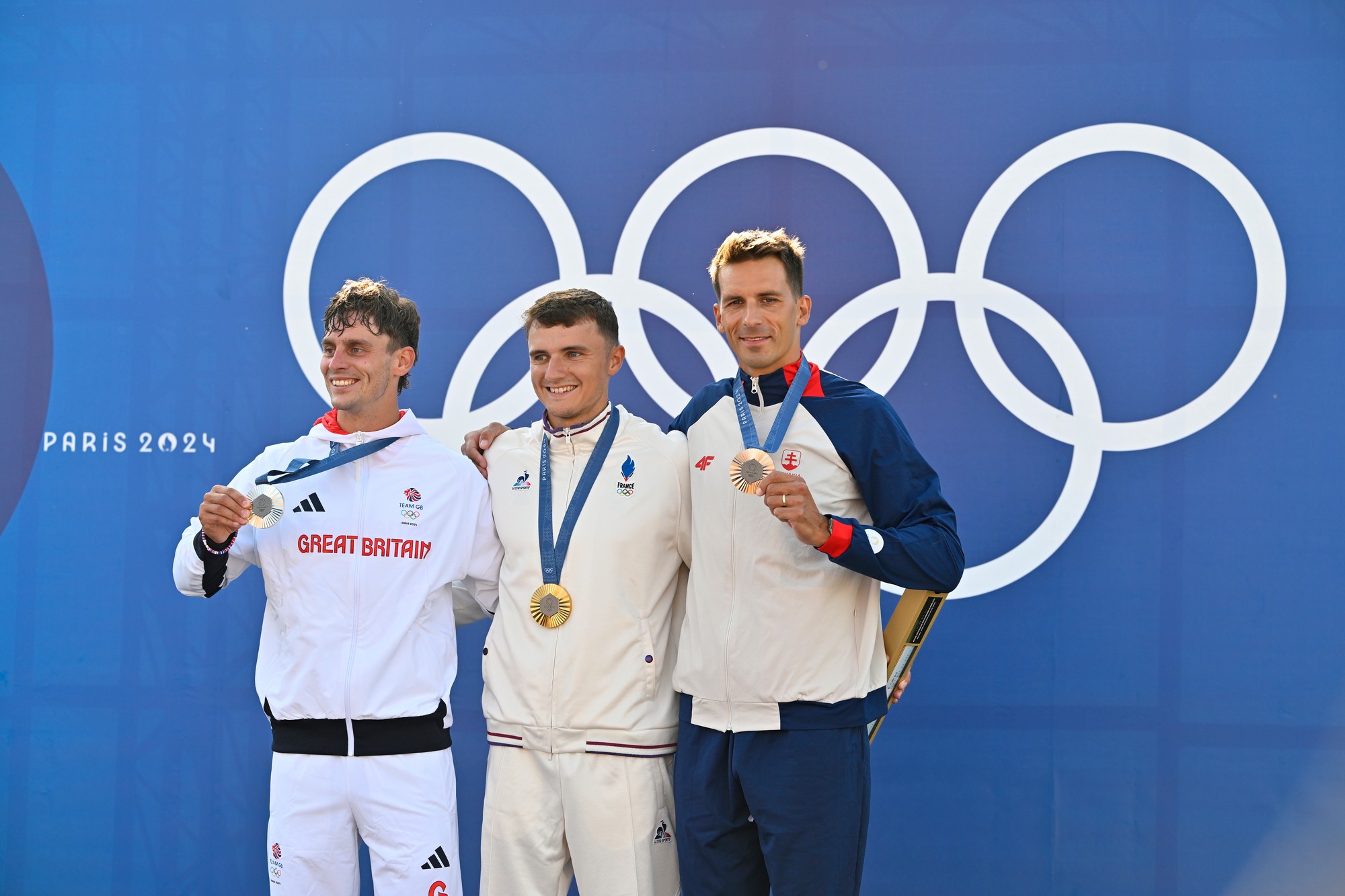 Sprava slovenský vodný slalomár Matej Beňuš s bronzovou medailou, zlatý Nicolas Gestin z Francúzska a strieborný Brit Adam Burgess.